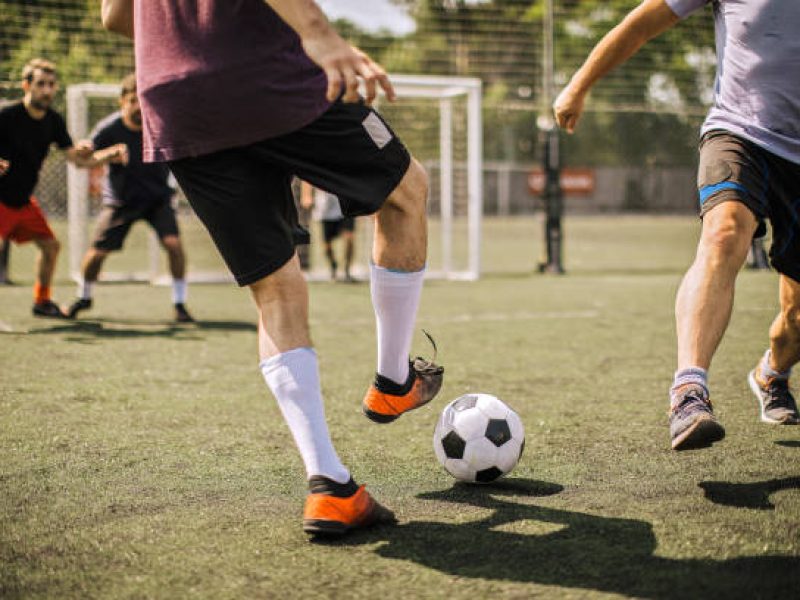 Group of men, soccer team on the field outdoors, training together.