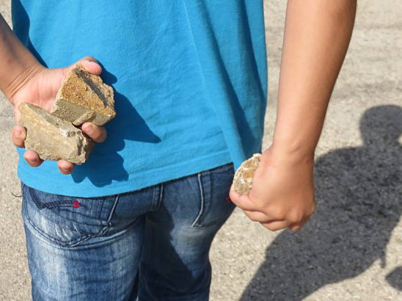 Furious boy about to throw a rock
