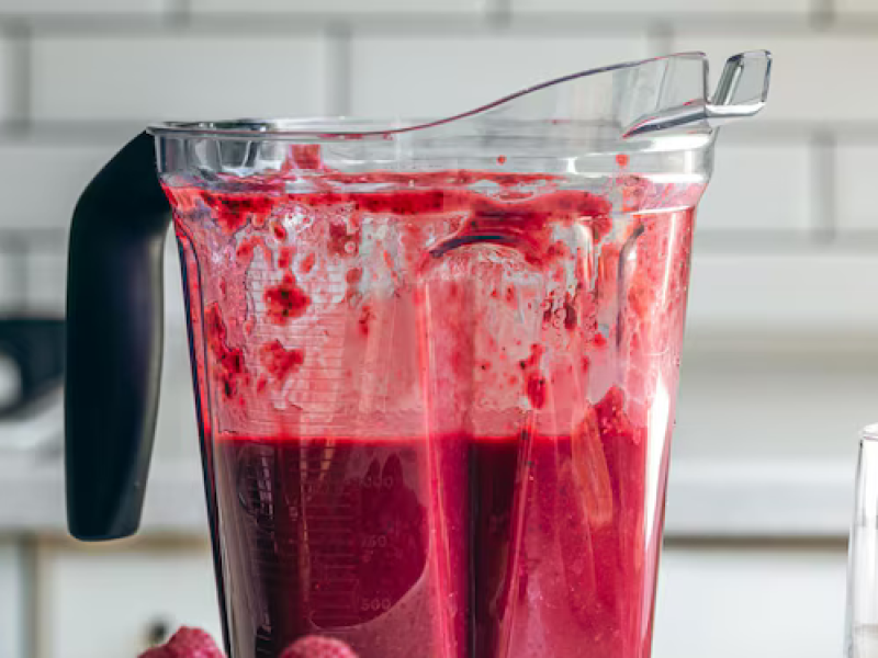liquidificador-com-smoothie-de-frutas-vermelhas-e-um-copo-vazio-na-mesa-da-cozinha_169016-41424
